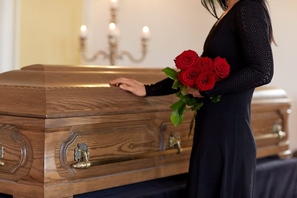 woman holding a red rose in a funeral
