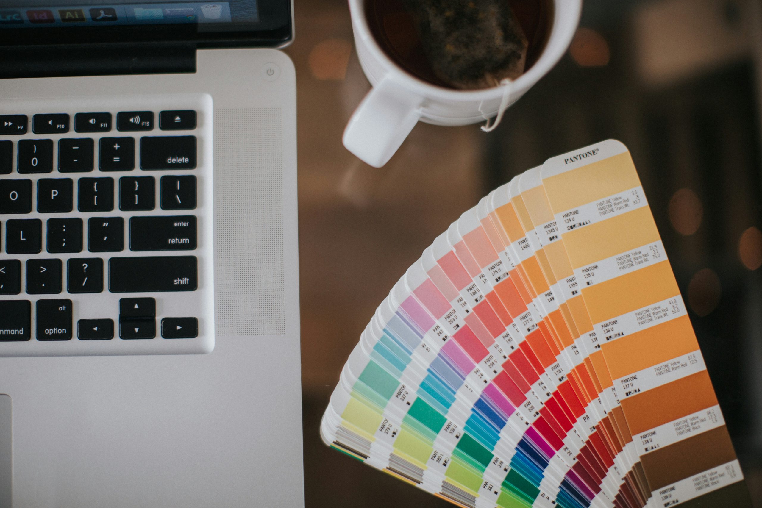 laptop and pantone color wheel on a desk